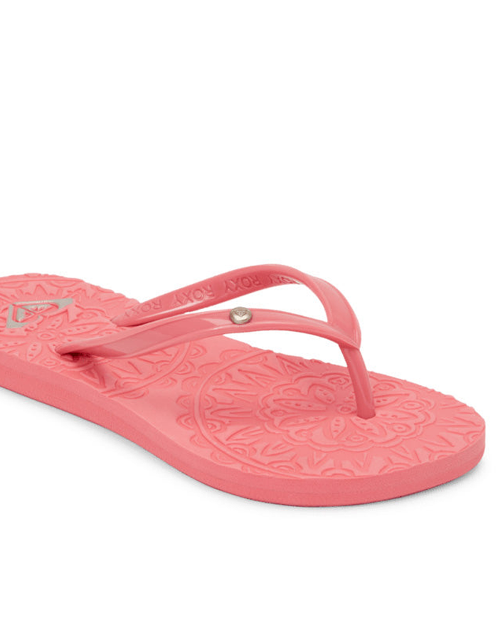 The Roxy Antilles Sandal features a pink color, textured floral footbed, and slim straps, shown angled on a white background—an ideal choice for comfortable beach style.