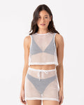 A woman poses against a white background in the Roxy Don't Mesh With Me Crop Top Cover Up in Egret, styled over a black bikini with its matching high-waisted loose-fit mesh skirt featuring a drawstring.