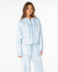 A woman wearing the Roxy Fringing Reefs Top in Cerulean Tie Dye stands against a plain white background, showcasing comfortable loungewear style.