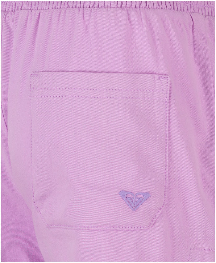 Close-up of the Girls' Soleil Short by Roxy in light purple brushed twill, showing an embroidered heart logo near the pocket and a smocked elastic waistband for comfort and style.