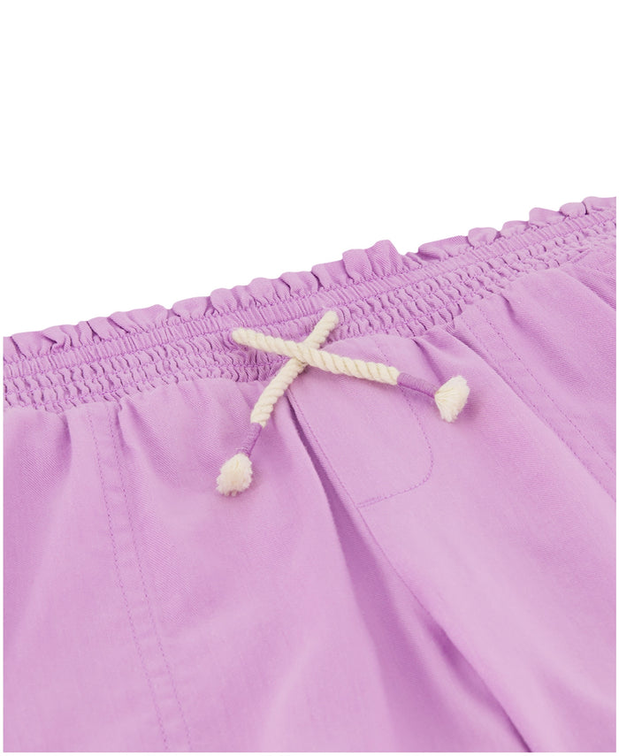 Close-up of the waistband on lavender Girls' Soleil Short by Roxy, featuring a smocked elastic top and a white twisted drawstring with knotted ends.