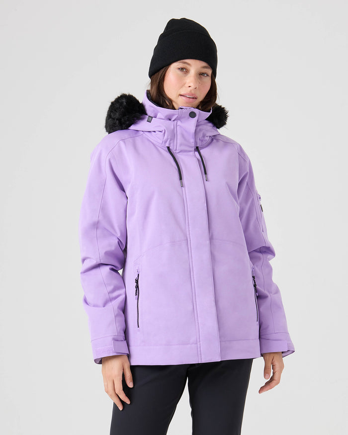 A person wearing the Roxy Meade Jacket in Sunlit Allium—a lilac women’s snow jacket with a hood, black fur trim, 10K protection, and a tailored fit—is paired with a black beanie and black pants, standing against a plain light gray background.