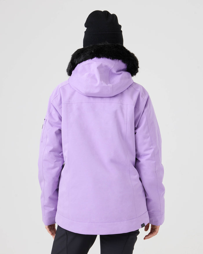 A person is seen from behind, standing against a plain light background, wearing the Roxy Meade Jacket—a light purple women’s snow jacket with a tailored fit and black fur-trimmed hood—paired with a black beanie.