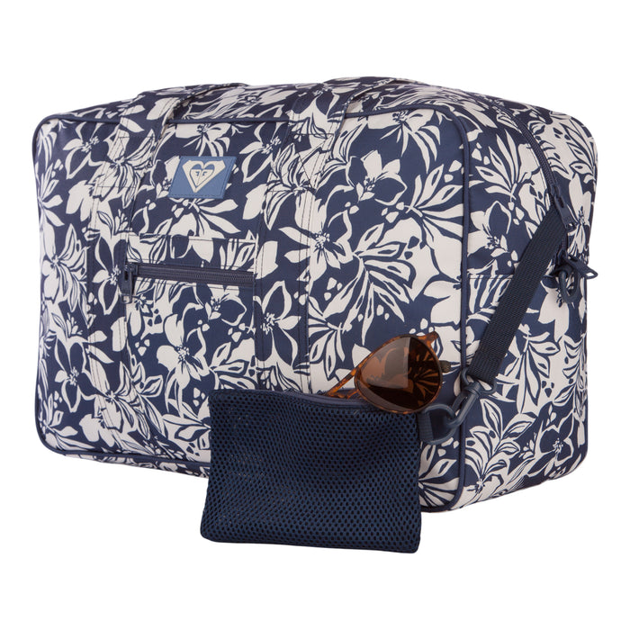 The Roxy Off Shore Duffel Bag, featuring a blue and white floral design, comes with a front pocket and a matching zippered pouch. Brown sunglasses are displayed in front of the pouch, all set against a white background. This stylish bag is an ideal choice for your next travel duffel.