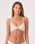 A woman with long brown hair wears the Roxy Polka Dots Knot Bralette Bikini Top in Neutral Combo, featuring adjustable straps. She faces forward and smiles slightly against a plain light background.