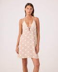A woman models the Roxy Polka Dots Plunge Dress Cover Up in Neutral Combo, featuring a sleeveless design, thin adjustable straps, white polka dots, a deep V-neckline, and a subtle front cutout.