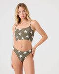 A woman models the Roxy Star Daze Tank Top in Deep Olive with white star prints, posing against a plain light background.