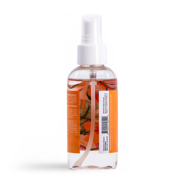 The Roxy Sun Drift Body Mist is shown in a clear spray bottle with a white nozzle and orange label, partially filled with liquid, against a white background. The label features text and a barcode, suggesting a sandalwood scent.