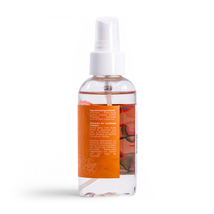 The Sun Drift Body Mist by Roxy comes in a clear plastic spray bottle with a white cap, featuring pink guava and hibiscus scent. The orange label displays ingredients and directions in white text, all set against a white background.