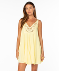 A woman with long brown hair models the Roxy Sunswept Mini Dress—sleeveless, loose-fitting, and yellow with lace bodice detail—against a plain white background for a casual chic vibe.