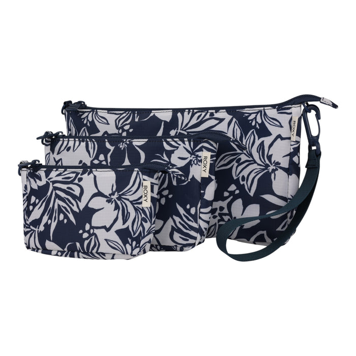 The Roxy Travel Pouch Set includes three zippered pouches in small, medium, and large sizes, each featuring a dark blue and white floral design, a detachable strap, and a small fabric tag—ideal for organized packing or carrying as a stylish crossbody pouch while on the go.