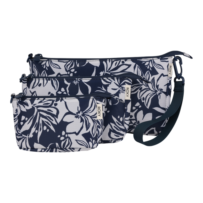 The Roxy Travel Pouch Set includes three zippered travel pouches in navy blue and white floral print, featuring varying sizes that stack together for easy packing organization, with the largest crossbody pouch equipped with a detachable wrist strap.