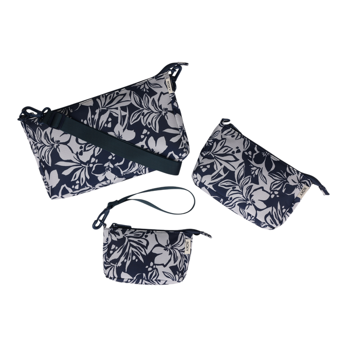 The Roxy Travel Pouch Set is displayed against a plain white background, featuring three navy blue bags with white floral prints—a crossbody bag, a medium travel pouch, and a small wristlet—ideal for keeping your essentials organized on the go.