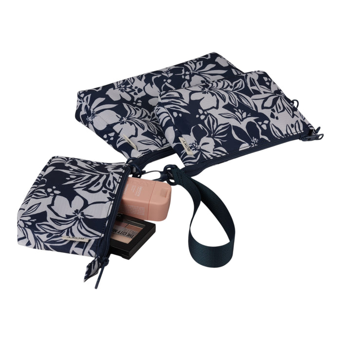 The Roxy Travel Pouch Set features two navy blue pouches with white floral patterns, one open to reveal makeup items inside. Connected by a strap, these versatile travel pouches are ideal for organized packing and can also be used as a stylish crossbody pouch while you’re on the go.