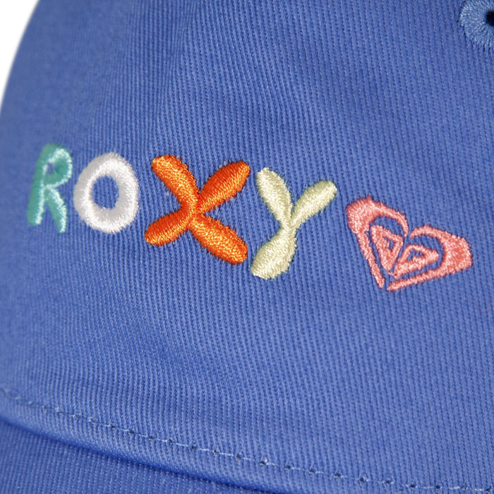 Close-up of blue fabric on the TW Next Level Baseball Cap by Roxy, featuring the word “ROXY” embroidered in colorful thread and a pink heart-shaped logo beside the text, making it a perfect casual accessory.